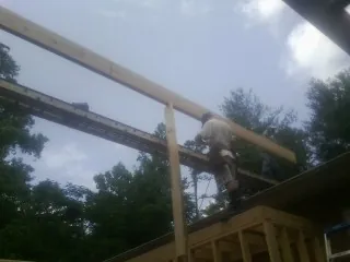 Carpenter setting a ridge beam over a new addition frame — Ice Dam Removal by Roofing Brothers in Echo