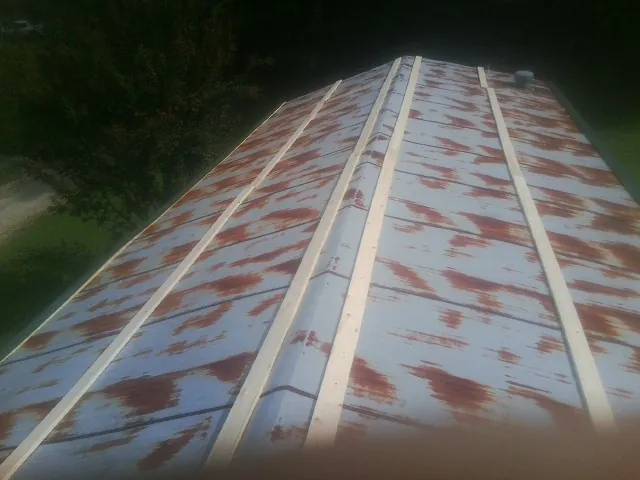 Rusted metal roof panels with new wood purlins before replacement — Storm Damage Roof Repair in Echo by Roofing Brothers